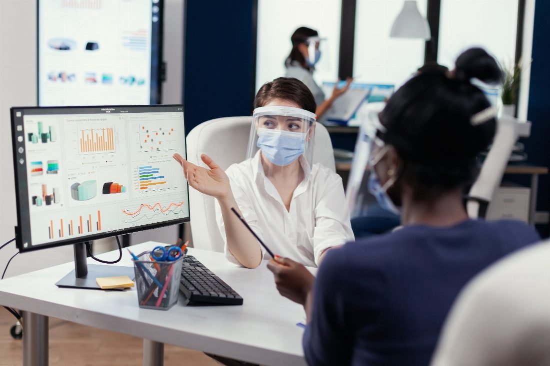 Team member walking a colleague through performance charts on a monitor
